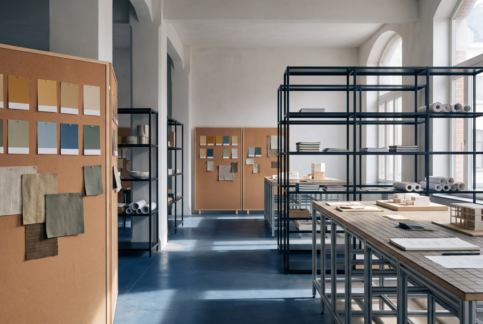 Licht atelier met materiaalborden, tafels en metalen rekken