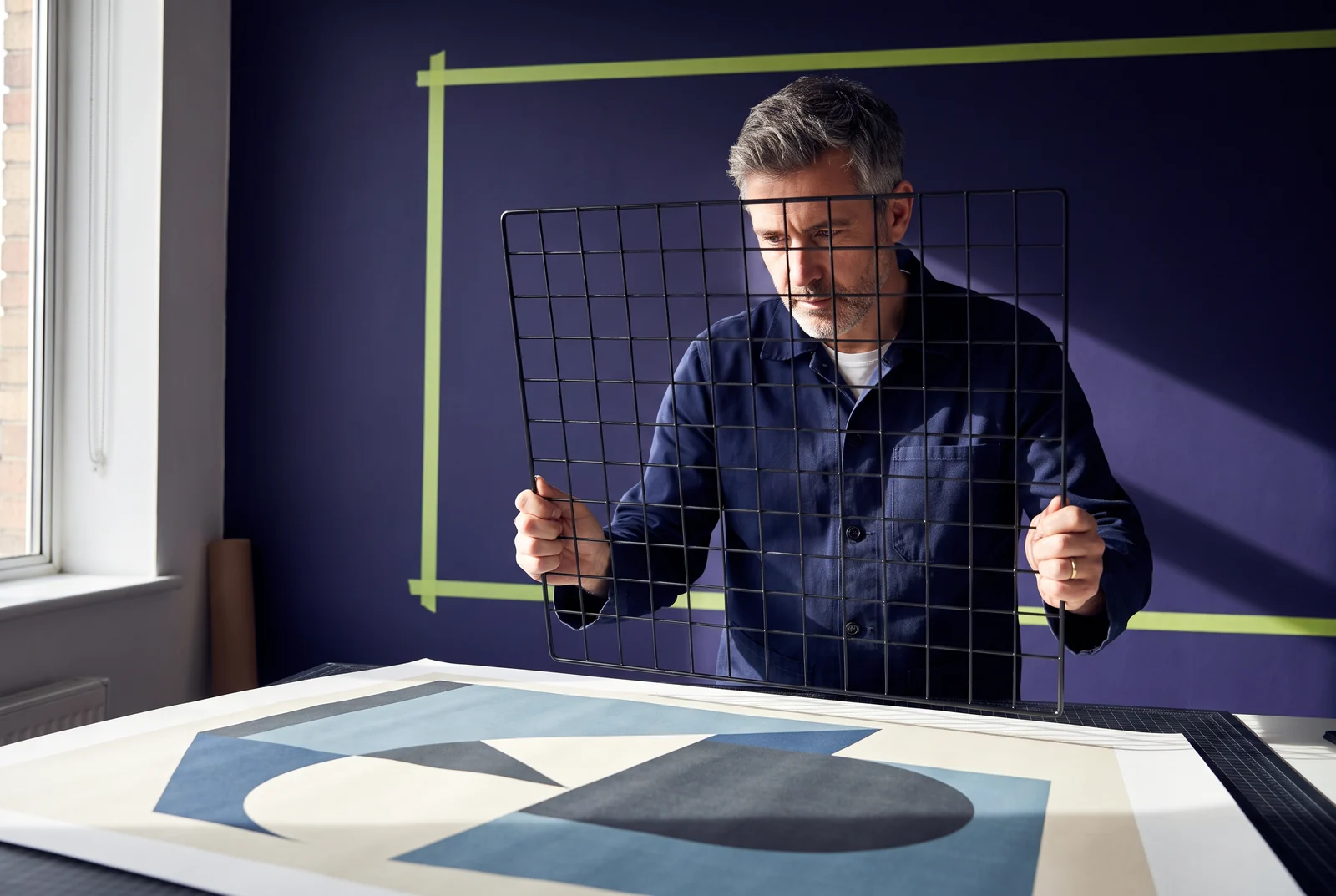 Ontwerper houdt een zwart metalen raster voor een geometrische compositie